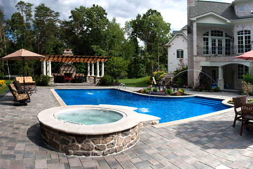 Artistic Tree & Landscape Creations hardscape services — modern home outdoor oasis with sone patio, hot tub, pool, pergola and fireplace